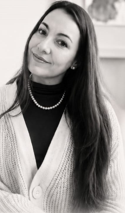 Retrato en blanco y negro de Paz, con chaleco claro y collar de perlas, mirando a cámara con una sonrisa serena